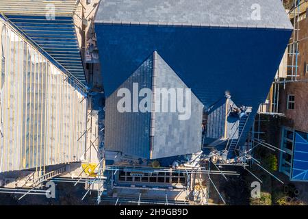 Foto aerea dei lavori di costruzione di un edificio in corso su un proprietà con impalcatura in su alla proprietà e tetti in funzione sul tetto della casa p Foto Stock