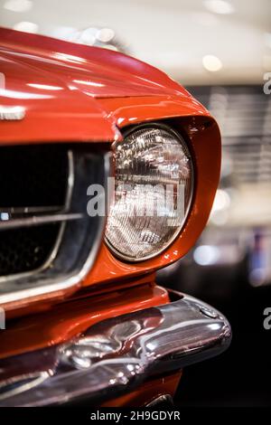 Primo piano dell'indicatore di direzione e del faro di una vettura retrò rossa. Foto Stock