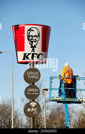 Guida attraverso il cartello KFC che viene eretto all'Elk Retail Park di Oldham, Greater Manchester Foto Stock