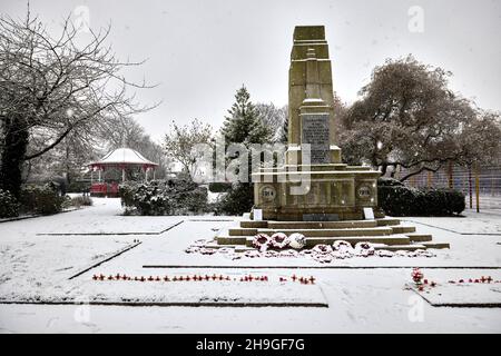 Neve d'inverno al Denton Victoria Park a Tameside con il suo palco edoardiano di grado II e il War Memorial del WW1 Foto Stock