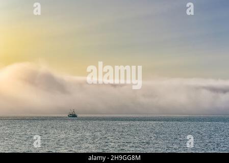 Barca da pesca e Fog Bank nel suono di Raasayof l'isola di Skye Foto Stock