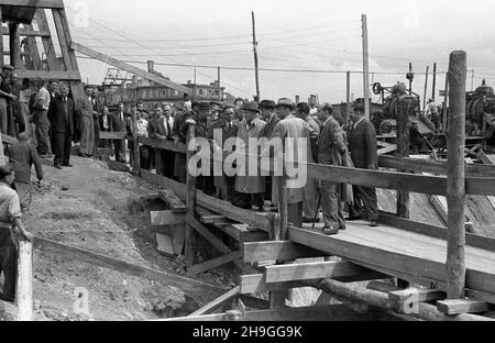 Warszawa, 1948-06-22. Wizyta prezydenta Boles³awa Bieruta na placu budowy trasy W-Z (trasy Wschód-Zachód). NZ. Delegacja z Boles³awem Bierutem na czele na drewnianym mostku ³¹cz¹cym plac Zamkowy z Krakowskim Przedmieœciem. wb PAP/Stanis³aw D¹browiecki Varsavia, 22 giugno 1948. Il presidente Boleslaw Bierut visita il sito di costruzione della strada W-Z (Est-Ovest). Nella foto: Una delegazione guidata da Boleslaw Bierut su un ponte di legno che collega Piazza Zamkowy con via Krakowskie Przedmiescie. wb PAP Foto Stock