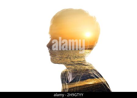 Combinazione isolata della silhouette di un viso bambino e di un condimento con un tramonto. Concetto di unità della natura e delle persone, pace interiore, cura della Th Foto Stock