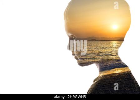 Combinazione isolata della silhouette di un viso bambino e di un condimento con un tramonto. Concetto di unità della natura e delle persone, pace interiore, cura della Th Foto Stock