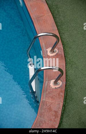 Piccola piscina in villa privata di lusso, con tavoli e sedie intorno, piante decorative Foto Stock