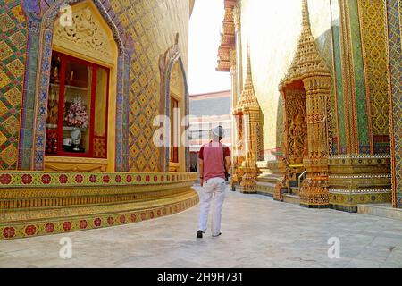 I visitatori camminano lungo il Corridoio circolare presso la base della Pagoda nel Tempio Buddista di Wat Ratchabophit, Bangkok, Thailandia Foto Stock