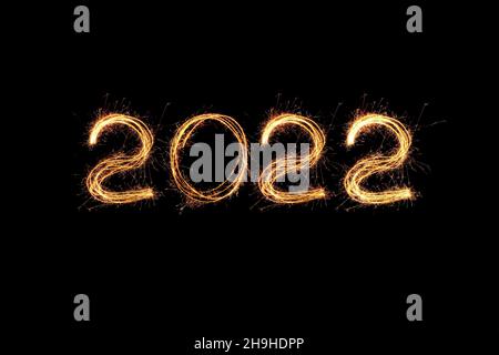 Luce di Capodanno 2022. Gli sparklers disegnano figure 2022. Bengala luci e lettera Foto Stock