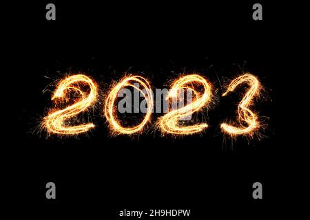Luce di Capodanno 2023. Gli sparklers disegnano figure 2023. Bengala luci e lettera Foto Stock