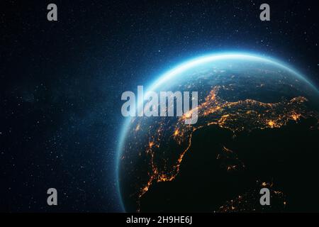 Pianeta Terra stupefacente con un bagliore blu e luci gialle delle città notturne nello spazio. Foto Stock