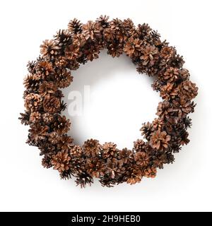 Corona di Natale di coni di pino naturale isolato su sfondo bianco. Decorazioni tradizionali per le vacanze natalizie in stile ecologico. Foto Stock