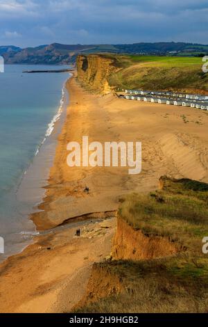 Un pozzo di luce solare autunnale illumina l'instabile East Cliff di arenaria e un enorme sito statico di casa mobile sulla Jurassic Coast a Burton Bradstock Foto Stock