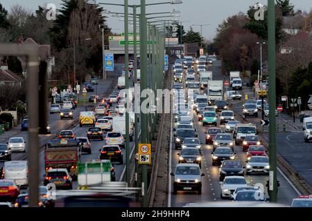 Traffico pesante dei pendolari in prima serata con fari accesi lungo la A3 Trunk Road al tramonto a South West London. Foto Stock