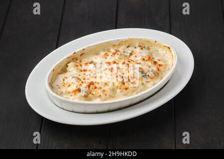 Casseruola di patate e boletus al forno con formaggio e pancetta Foto Stock