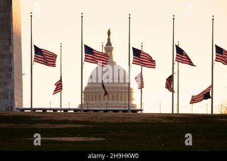 Washington, DC, Stati Uniti. 7 dicembre 2021. Le bandiere nazionali DEGLI STATI UNITI volano a metà del personale alla base del monumento di Washington per proclamazione presidenziale, per onorare il defunto ex leader della maggioranza del Senato degli Stati Uniti Bob Dole, a Washington, DC, USA, 07 dicembre 2021. Dole morì il 05 dicembre all'età di 98 anni. Credit: Michael Reynolds/Pool via CNP/dpa/Alamy Live News Foto Stock