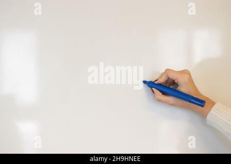 donna che scrive su lavagna bianca Foto Stock