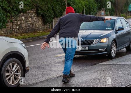 Un uomo lotta per camminare contro gli alti venti a Bantry, West Cork, Irlanda dopo che Storm barra ha colpito il Regno Unito e l'Irlanda con venti dirompenti, pioggia pesante e neve. Data foto: Martedì 7 dicembre 2021. Foto Stock