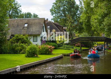 GIETHOORN, PAESI BASSI - AGOSTO 01 2017: Visitatori sconosciuti nel giro turistico in barca in un canale a Giethoorn. Le belle case e il giardinaggio Foto Stock