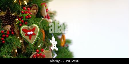 Banner. Albero di Natale decorato in verde con giocattoli su sfondo bianco Foto Stock