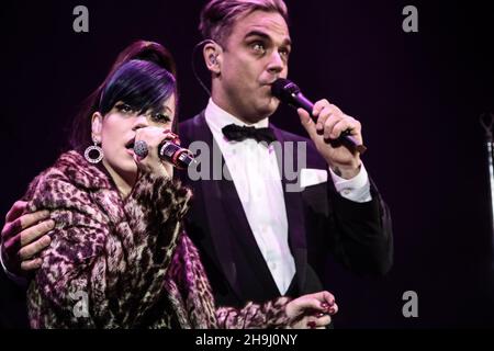 Lily Allen e Robbie Williams si esibiscono dal vivo sul palco all'evento Under1Roof Fund-Raising per la Kids Company presso l'Hammersmith Apollo di Londra. Foto Stock