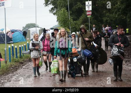 Le persone che arrivano il primo giorno sono aperte al pubblico a Glastonbury 2016 in Worthy Farm sotto la pioggia Foto Stock