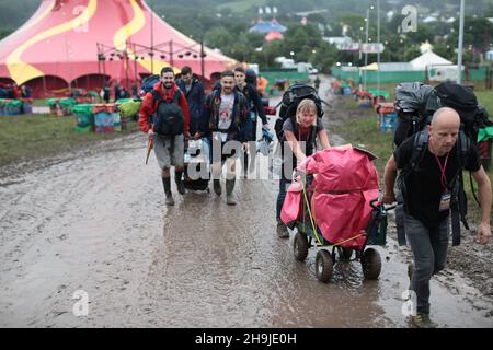 Le persone che arrivano il primo giorno sono aperte al pubblico a Glastonbury 2016 in Worthy Farm sotto la pioggia Foto Stock