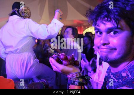 Un festaiolo dopo aver ricevuto l'uva da uno dei membri del Drone Club durante la loro esibizione nella tenda Sunrise a Latitude 2016. Viste generali il giorno 2 al festival 2016 di latitudine a Southwold, Suffolk Foto Stock