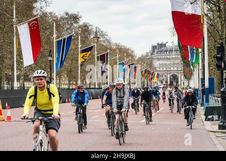 Ciclisti che cavalcano sul Mall nel centro di Londra dopo essere stato chiuso al traffico e fiancheggiato da bandiere nazionali in preparazione all'arrivo dei leader per il Commonwealth Capi di Governo del 2018 e per la maratona di Londra. Data foto: Martedì 17 aprile 2018. Il credito fotografico dovrebbe essere: Richard Grey/EMPICS Foto Stock