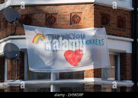 Un banner che mostra sostegno e ringraziamenti per l'NHS nelle finestre delle case di Ealing, Londra. Data foto: Domenica 19 aprile 2020. Il credito fotografico dovrebbe essere: Richard Grey/EMPICS Foto Stock