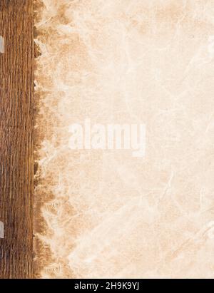 Sfondo vintage retro paper con bordo sinistro. Antica pergamena invecchiata su una scrivania in legno. Senza cuciture e inclinabili in alto e in basso per consentire un terminale Foto Stock