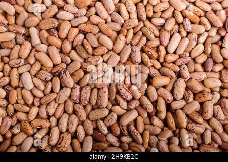 Sfondo naturale di molti fagioli rossi biologici freschi in una scatola di plastica in luce calda, vista dall'alto o piatto di cibo vegano biologico fotografato con f morbido Foto Stock