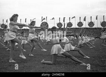 Warszawa, 1948-08-19. Pierwsze ogólnopolskie Igrzyska Sportowe Zwi¹zków Zawodowych (19-22.VIII) na stadionie Wojskowego Klubu Sportowego Legia, w których rywalizowali w 11 dyscyplinach reprezentanci 17 zwi¹zków zawodowych. NZ. Grupowe pokazy gimastyczne podczas jumacji zawodów. W tle emblematy zwi¹zków. ka PAP Varsavia, 19 agosto 1948. La prima competizione sportiva sindacale nazionale (agosto 19-22) che si tiene allo stadio del Club militare sportivo Legia. La manifestazione ha riunito rappresentanti di 17 sindacati che hanno gareggiato in 11 discipline. Nella foto: Spettacolo di ginnastica di gruppo durante il Foto Stock