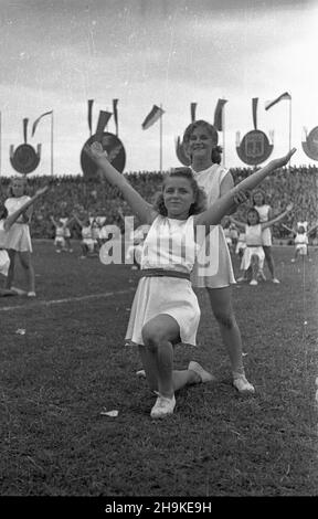 Warszawa, 1948-08-19. Pierwsze ogólnopolskie Igrzyska Sportowe Zwi¹zków Zawodowych (19-22.VIII) na stadionie Wojskowego Klubu Sportowego Legia, w których rywalizowali w 11 dyscyplinach reprezentanci 17 zwi¹zków zawodowych. NZ. Grupowe pokazy gimastyczne podczas jumacji zawodów. W tle emblematy zwi¹zków. ka PAP Varsavia, 19 agosto 1948. La prima competizione sportiva sindacale nazionale (agosto 19-22) che si tiene allo stadio del Club militare sportivo Legia. La manifestazione ha riunito rappresentanti di 17 sindacati che hanno gareggiato in 11 discipline. Nella foto: Spettacolo di ginnastica di gruppo durante il Foto Stock