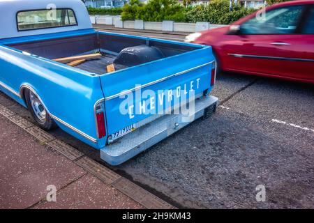 Vista posteriore di un veicolo parcheggiato Chevrolet C10 in blu pallido con una macchina rossa che passa sullo sfondo, sul lungomare di Hastings il 31 luglio 2021 Foto Stock