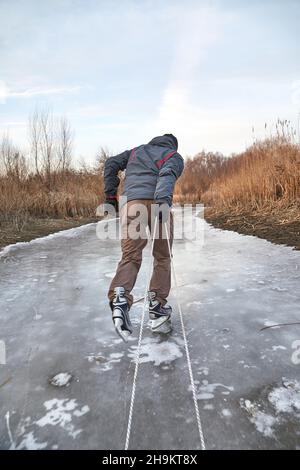 Uomo pattinaggio su ghiaccio che tira la slitta su ghiaccio Foto Stock