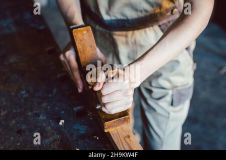 Primo piano su mano di falegname donna con piallatrice di legno Foto Stock