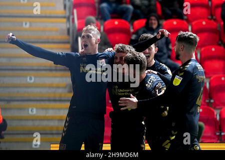 Sam Hoskins (centro) di Northampton Town festeggia dopo aver segnato il secondo gol del gioco durante la partita della Sky Bet League Two al St James Park, Exeter. Data foto: Martedì 7 dicembre 2021. Foto Stock