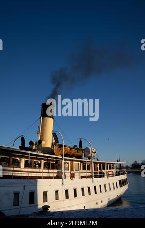 Inquinamento atmosferico a Stoccolma. Camino di barca con fumo nero che esce da esso. Tema del cambiamento climatico e delle emissioni di carbonio. Foto Stock