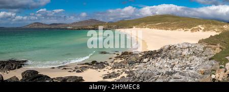 Una vista panoramica di rocce, sabbia e mare nella bellissima spiaggia Traigh IAR con cielo blu in estate, Horgabost, Isola di Harris, Scozia, Regno Unito Foto Stock