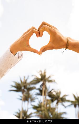 Le mani si uniscono formano un cuore, simbolo dell'amore. Foto Stock