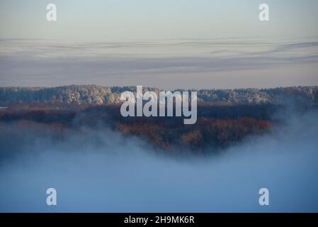 Paesaggio gelido del nord. La nebbia sorge dalla superficie di un fiume non congelato Foto Stock