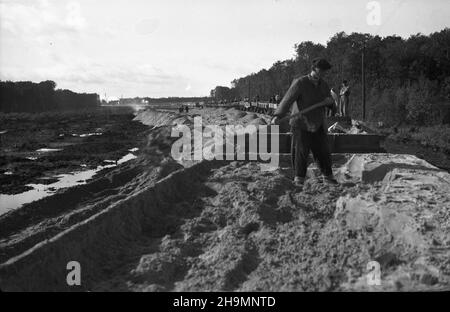 Szczecin, 1948-10. Teren budowy stacji rozrz¹dowej, naprzeciwko budowy portu prze³adunków masowych, po prawej stronie od ul. Czajkowskiego. Têdy bêd¹ jeŸdziæ wagony z wêglem ze Œl¹ska. NZ. Budowa nasypu, roz³adunek wagonów dowo¿¹cych piasek. mw PAP Dok³adny dzieñ wydarzenia nieustalony. Szczecin, ottobre 1948. Il cantiere di costruzione del cantiere di marshalling si trova di fronte al cantiere del porto di ricarico del carico, sul lato destro di via Czajkowskiego. Il percorso per i treni con carbone dalla Slesia. Nella foto: Il lungofiume ferroviario, lo scarico di vagoni ferroviari con sabbia. mw PAP Foto Stock