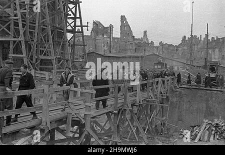 Warszawa, 1948-10. Budowa Trasy W-Z (Wschód-Zachód). NZ. Zwiedzanie placu budowy tunelu przy placu Zamkowym. Na pierwszym planie k³adka ³¹cz¹ca Krakowskie Przedmieœcie z pl. Zamkowym. W g³êbi, obubowana rusztowaniami, kamienica Leszczyñskich (L). pw PAP Dok³adny dzieñ wydarzenia nieustalony. Varsavia, 1949 ottobre. La costruzione del percorso W-Z (Est-Ovest). Nella foto: Visita al sito di costruzione di un tunnel sotto Piazza Zamkowy. In primo piano un cavalcavia che collega Krakowskie Przedmieœcie a Piazza Zamkowy. Sullo sfondo il Leszczuynski tenement dietro il ponteggio (a sinistra). pw PAP Foto Stock