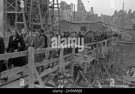 Warszawa, 1948-10. Budowa Trasy W-Z (Wschód-Zachód). NZ. Zwiedzanie placu budowy tunelu przy placu Zamkowym. Na pierwszym planie k³adka ³¹cz¹ca Krakowskie Przedmieœcie z pl. Zamkowym. W g³êbi, obubowana rusztowaniami, kamienica Leszczyñskich (L). pw PAP Dok³adny dzieñ wydarzenia nieustalony. Varsavia, 1949 ottobre. La costruzione del percorso W-Z (Est-Ovest). Nella foto: Visita al sito di costruzione di un tunnel sotto Piazza Zamkowy. In primo piano un cavalcavia che collega Krakowskie Przedmieœcie a Piazza Zamkowy. Sullo sfondo il Leszczuynski tenement dietro il ponteggio (a sinistra). pw PAP Foto Stock