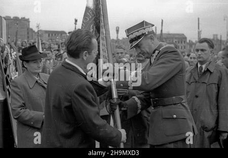 Warszawa, 1948-10-03. Wrêczanie sztandaru okrêgowi sto³ecznemu Zwi¹zku Inwalidów Wojennych, uroczystoœæ na placu Zwyciêstwa. Sztandar, jako dowód uznania i czci ufundowa³o spo³eczeñstwo Warszawy. NZ. Przekazywanie sztandaru, przewodnicz¹cy Sto³eczej Rady Narodowej Stanis³aw Sankowski (L) wrêcza go genera³owi brygady Piotrowi Jaroszewiczowi. Z prawej wiceprezydent Warszawy Boles³aw Jaszczuk. mw PAP Varsavia, 3 ottobre 1948. La cerimonia di consegna della bandiera al distretto della capitale dell'Unione dei Veterani di guerra (ZIW) in piazza Zwyciestwa (Vittoria). La bandiera, il segno dell'onore e del riconoscimento Foto Stock