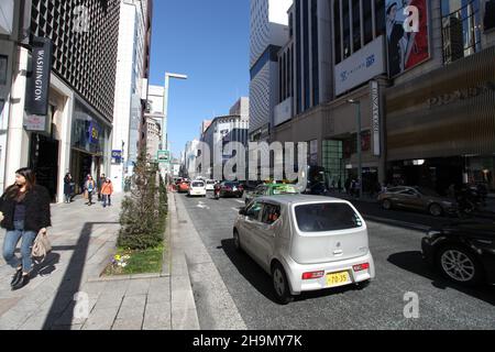 Chuo-dori Ave nel cuore di Ginza, Tokyo, con edifici alti, boutique di lusso, ristoranti e gente che cammina sulla strada. Foto Stock