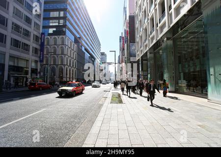 Chuo-dori Ave nel cuore di Ginza, Tokyo, con edifici alti, boutique di lusso, ristoranti e gente che cammina sulla strada. Foto Stock
