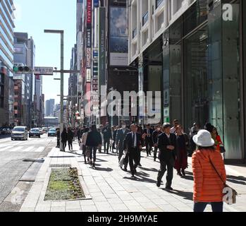 Chuo-dori Ave nel cuore di Ginza, Tokyo, con edifici alti, boutique di lusso, ristoranti e gente che cammina sulla strada. Foto Stock