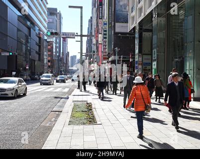 Chuo-dori Ave nel cuore di Ginza, Tokyo, con edifici alti, boutique di lusso, ristoranti e gente che cammina sulla strada. Foto Stock