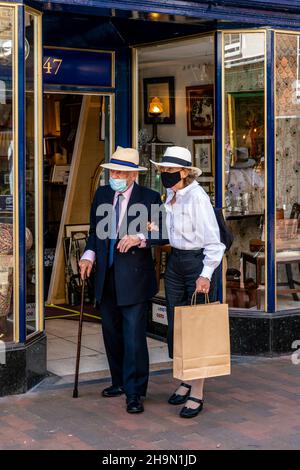 Una coppia anziana che indossa maschere facciali Shopping in High Street, Lewes, East Sussex, UK. Foto Stock