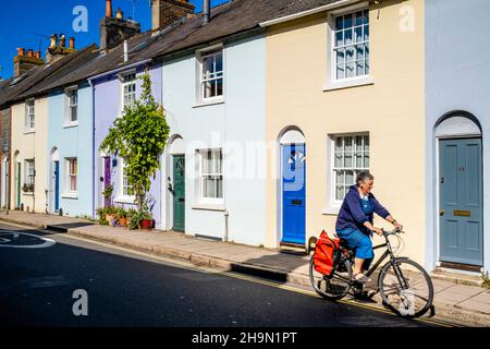 A Woman Cycles Down Southover High Street nella contea di Lewes, Sussex, Regno Unito. Foto Stock
